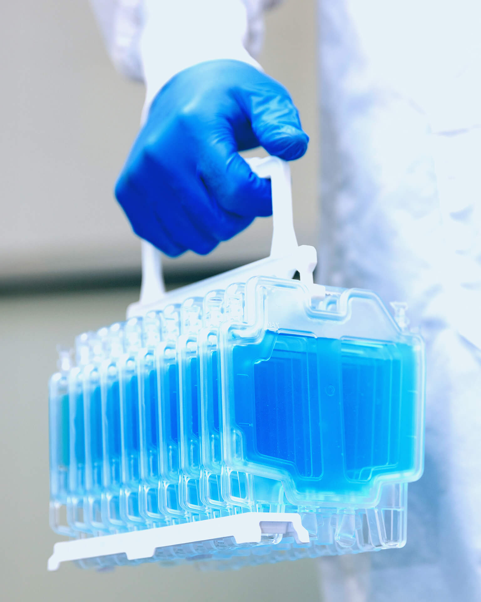 Technician carrying 10 CellSeal CryoCases in the stand for Cell and Gene Therapy Storage.