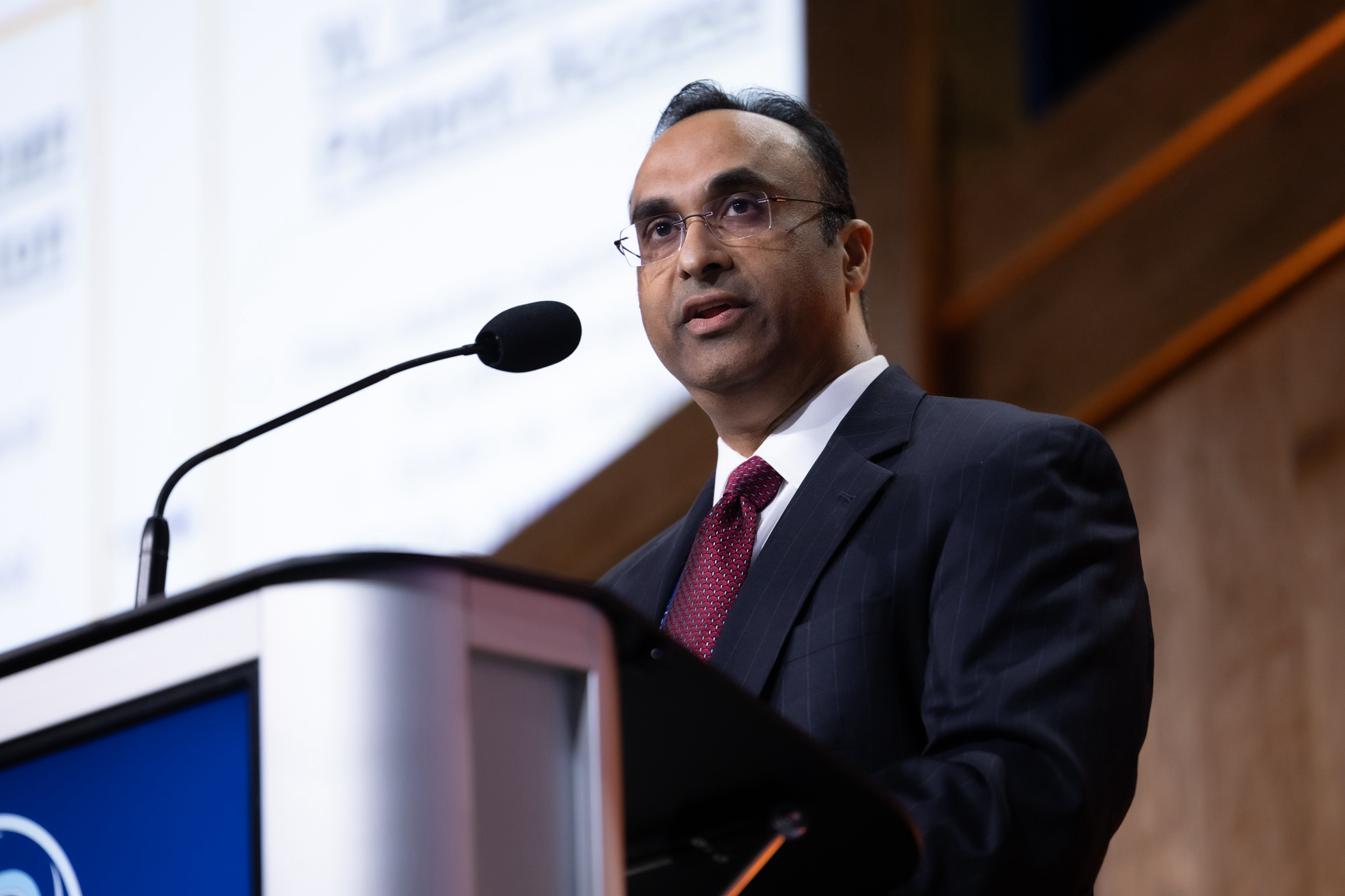 Dr. Aby J. Mathew speaking at a scientific conference podium, addressing an audience on advancements in biopreservation and cell therapy manufacturing.