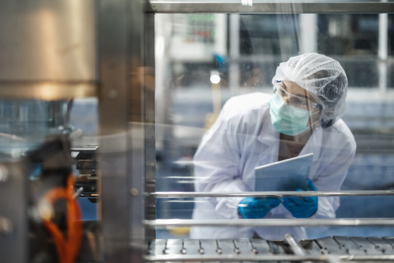 Cleanroom technician monitoring cell therapy manufacturing operations, representing quality control, process oversight, and regulatory readiness.